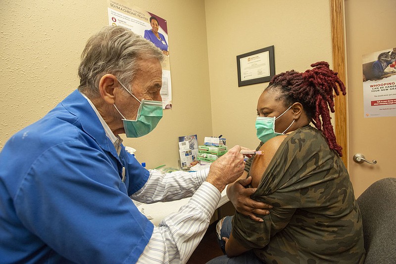 Carl Collier, pharmacist at Collier Drug in Fayetteville, administers a covid-19 booster shot to Chrystal McPherson of Prairie Grove Thursday Jan. 13, 2022. (NWA Democrat-Gazette/J.T. Wampler)