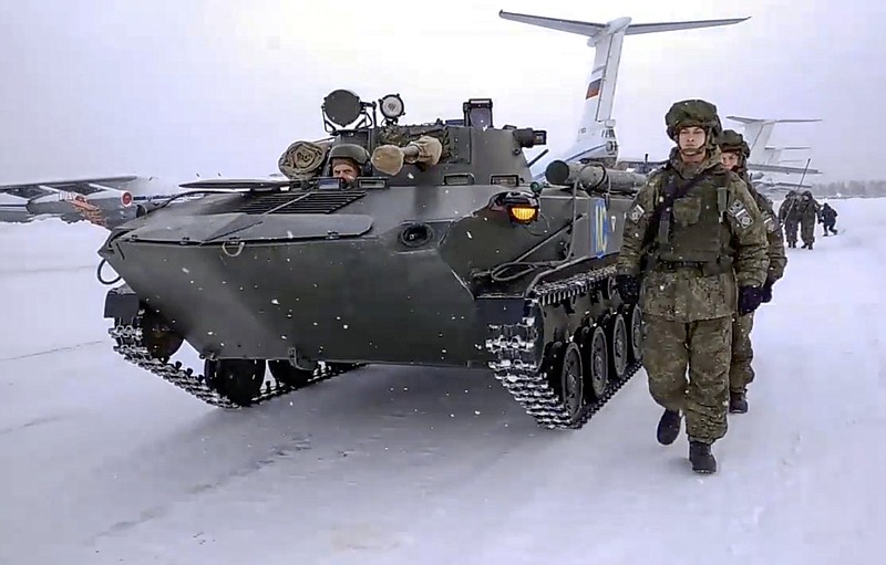 In this photo taken from video provided by the Russian Defense Ministry Press Service, Russian peacekeepers of the Collective Security Treaty Organization walk next to their military vehicle after leaving a Russian military plane after withdrawing its troops at an airport outside Ivanovo, Russia, Saturday, Jan. 15, 2022. Russia's defense ministry says the troops that were deployed to Kazakhstan as violent demonstrations shook the country have returned home. The troops were part of a force sent as peacekeepers by the Collective Treaty Security Organization, a Russia-led alliance of six former Soviet states. The CSTO approved the force of more than 2,000 on Jan. 5 at the request of Kazakh President Kassym-Jomart Tokayev. (Russian Defense Ministry Press Service via AP)
