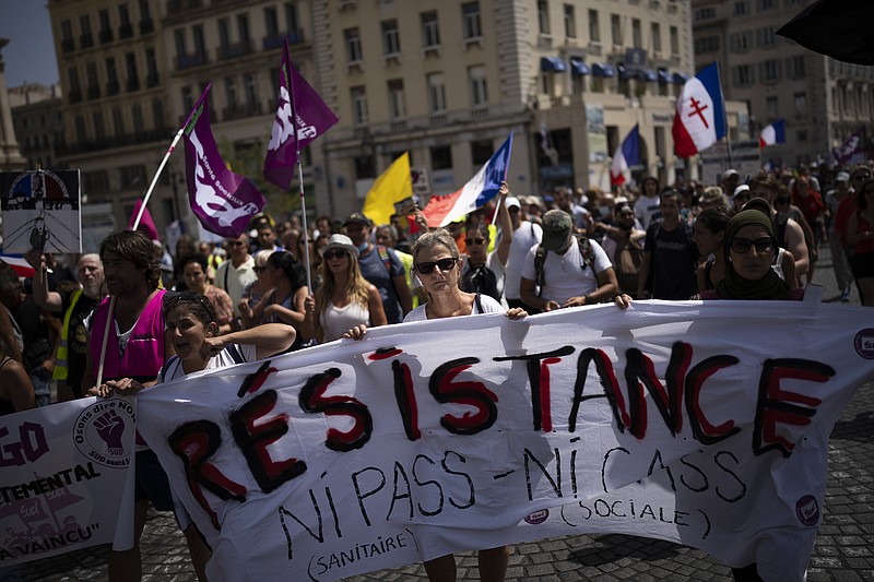 FILE - Potesters march during a demonstration in Marseille, southern France, Saturday, Aug. 14, 2021. Thousands of people, from families to far-right sympathizers, marched in dozens of cities across France for a fifth straight Saturday to denounce a COVID-19 health pass needed to access restaurant, long-distance trains and other venues. (AP Photo/Daniel Cole, File)