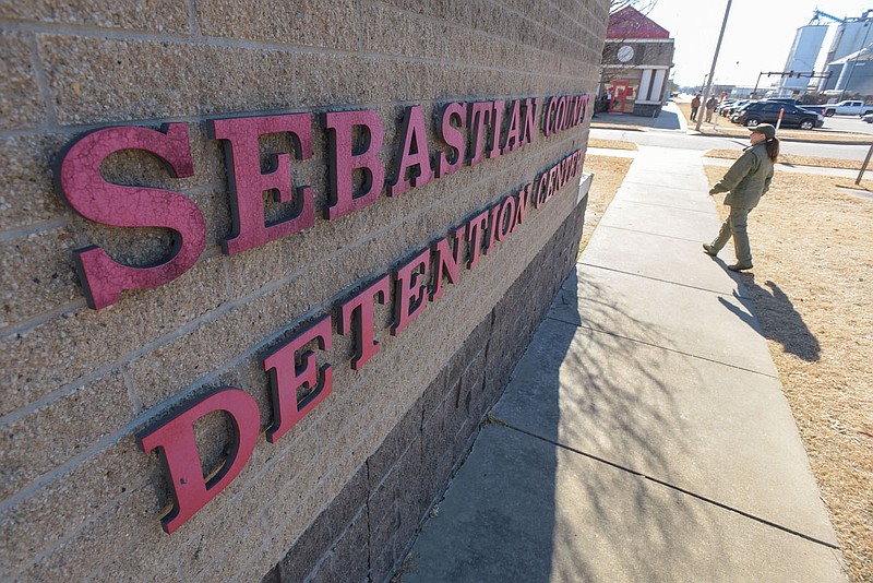 An employee walks near the entrance of the Sebastian County Detention Center on Friday in Fort Smith. Due to staff absences from covid-19, the Sheriff's Office this week used its patrol and courts divisions to help run the jail. Go to nwaonline.com/220123Daily/ for today's photo gallery.
(NWA Democrat-Gazette/Hank Layton)