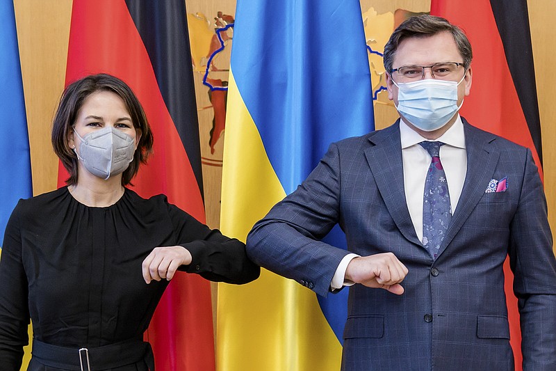 In this photo provided by Ukrainian Foreign Ministry Press Office, Ukrainian Foreign Minister Dmytro Kuleba, right, and German Foreign Minister Annalena Baerbock greet each other during their meeting in Kyiv, Ukraine, Monday, Jan. 17, 2022. (Ukrainian Foreign Ministry Press Office via AP)