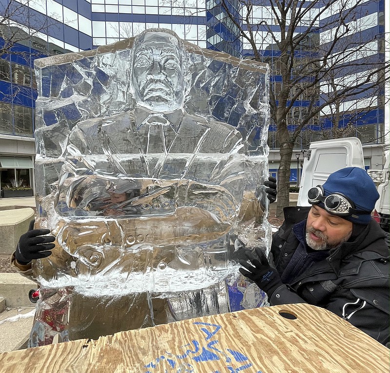 Sculptor Max Zuleta assembles an ice sculpture of Martin Luther King Jr. prior to a ceremony where the last few blocks of what was 3rd Street downtown that have been renamed Dr. Martin Luther King Jr. Drive at its intersection with W. Wisconsin Ave. Monday, Jan. 17, 2022 in Milwaukee, Wis. The 1400 pound ice sculpture took 14 hours to create, which is longer than normal, because the face had to be specific to King. He is from Franksville, Wis. (Mark Hoffman/Milwaukee Journal-Sentinel via AP)