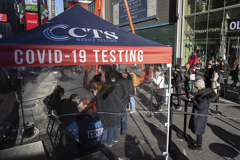 FILE - People wait in line at covid-19 testing site in Times Square on Dec. 3, 2021, in New York. The fast-moving omicron variant may cause less severe disease on average, but covid-19 deaths in the U.S. are climbing and modelers forecast 50,000 to 300,000 more Americans could die by the time the wave subsides in mid-March.  (AP Photo/Yuki Iwamura, File)