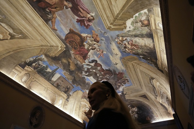 FILE - Princess Rita Boncompagni Ludovisi stands beneath a fresco by Italian Baroque painter Giovanni Francesco Barbieri, known as Guercino, inside The Casino dell'Aurora, also known as Villa Ludovisi, in Rome, Tuesday, Nov. 30, 2021.  The villa containing the only known ceiling painted by Caravaggio goes on the court-ordered auction block Tuesday, Jan. 18, 2022 with an estimated value of nearly a half-billion euros (dollars), thanks to an inheritance dispute pitting the heirs of one of Rome&#x2019;s aristocratic families against their step-mother, a Texas-born princess. (AP Photo/Gregorio Borgia, File)