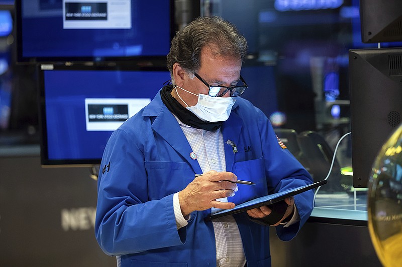 In this photo provided by the New York Stock Exchange, trader Sal Suarino works on the trading floor, Tuesday, Jan. 18, 2022. Stocks fell broadly in morning trading on Wall Street Tuesday as investors review the latest batch of corporate earnings and continue monitoring rising inflation and the virus pandemic. (Allie Joseph/New York Stock Exchange via AP)