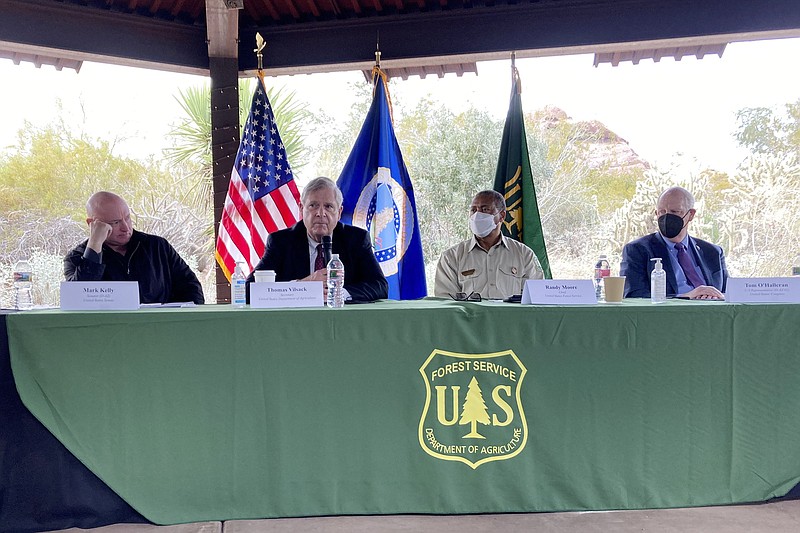 U.S. Sen. Mark Kelly, D-Ariz., left, Agriculture Secretary Tom Vilsack, Forest Service Chief Randy Moore and U.S. Rep. Tom O'Halleran, D-Ariz., discuss forest fires at the Desert Botanical Garden in Phoenix on Tuesday, Jan. 18, 2022. The Biden administration plans to significantly expand efforts to stave off catastrophic wildfires that have torched areas of the U.S. West. (AP Photo/Jonathan J. Cooper)