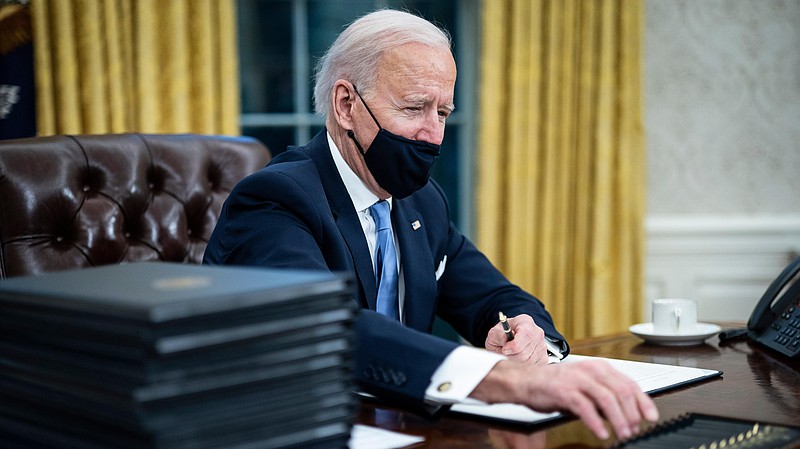President Biden signs a series of executive orders on the pandemic response hours after being sworn into office on Jan. 20, 2021. MUST CREDIT: Washington Post photo by Jabin Botsford