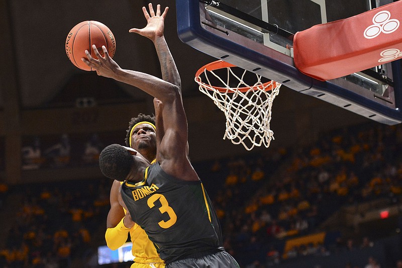 West Virginia guard Malik Curry (10) blocks the dunk by Baylor guard Dale Bonner (3) during the second half of an NCAA college basketball game in Morgantown, W.Va., Tuesday, Jan. 18, 2022. (William Wotring)