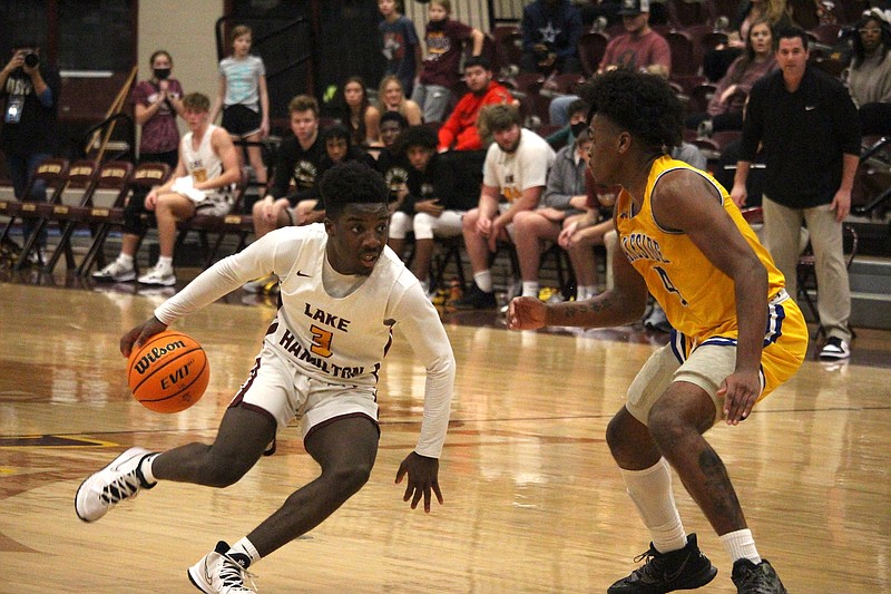 Lake Hamilton's Demetrius Sharp (3) drives past Lakeside's Alveon Harris (4) at Wolf Arena Jan. 11. - Photo by Krishnan Collins of The Sentinel-Record