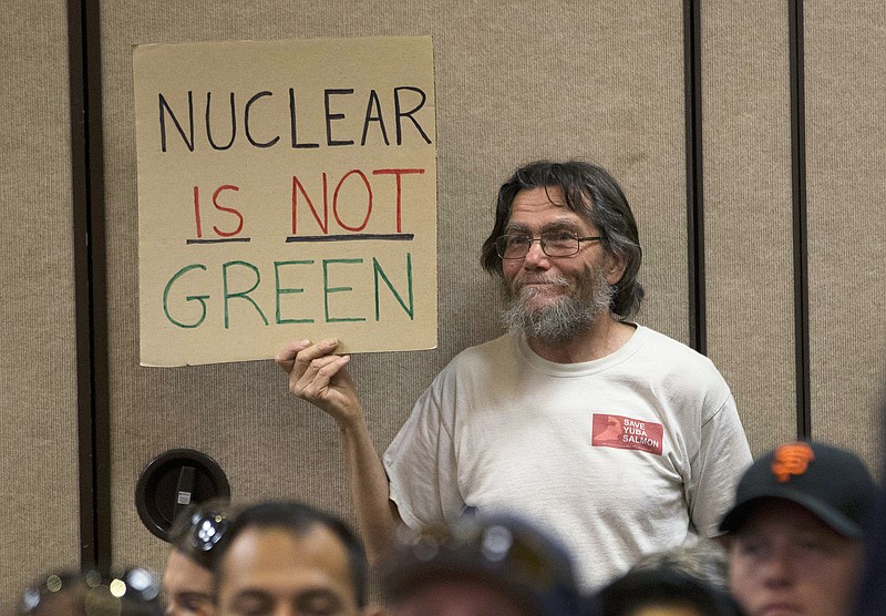 FILE - Peter Galbraith displays his opposition to a proposal to waive an environmental review of the Diablo Canyon Nuclear Power plant before renewing the plant's license, Tuesday, June 28, 2016, in Sacramento, Calif. As climate change pushes states in the U.S. to dramatically cut their use of fossil fuels, many are coming to the conclusion that solar, wind and other renewable power sources won't be enough to keep the lights on. Nuclear power is emerging as an answer to fill the gap as states transition away from coal, oil and natural gas to reduce greenhouse gas emissions and stave off the worst effects of a warming planet.   (AP Photo/Rich Pedroncelli, File)