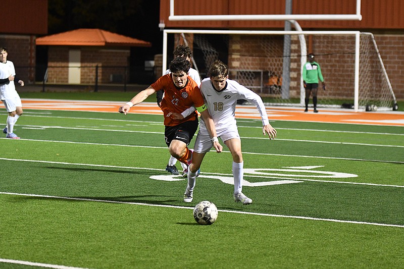 Texas High striker Austin Miller, No. 22, fights for possession with Pleasant Grove’s Peyton Legrand, No. 18. Miller had 4 goals for the Tigers who beat the Hawks 6-0 on a windy night at Tigers Stadium at Grim Park in Texarkana. (Photo by Kevin Sutton)