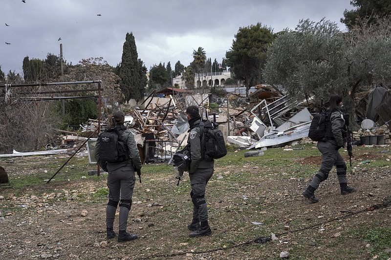 Israeli border police officers stand next to the ruins of a Palestinian house demolished by the Jerusalem municipality, in the flashpoint east Jerusalem neighborhood of Sheikh Jarrah, Wednesday, Jan. 19, 2022. Israeli police on Wednesday evicted Palestinian residents from the disputed property and demolished the building, days after a tense standoff. (AP Photo/Mahmoud Illean)