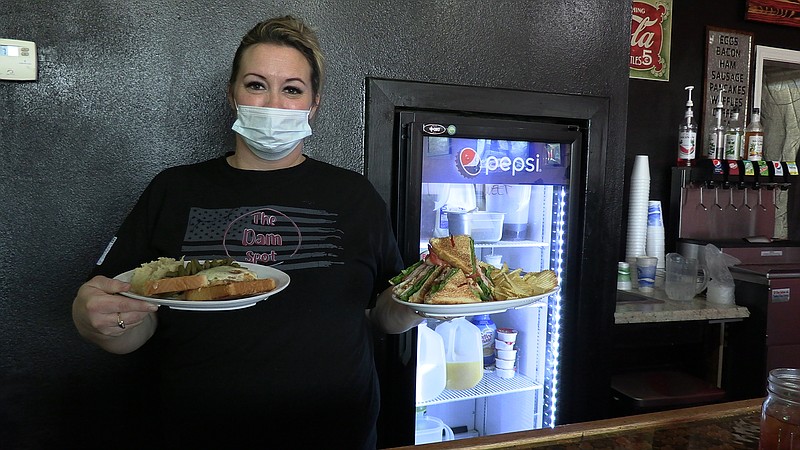 Waitress Ericca Komula holds plates of food at The Dam Spot on Thursday. - Photo by Andrew Mobley of The Sentinel-Record.