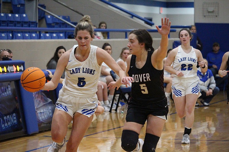 Jessieville's Reagan Jones (5) drives past Dover's Madeline Bowden (5) at Jessieville Sports Arena Thursday night. - Photo by Krishnan Collins of The Sentinel-Record