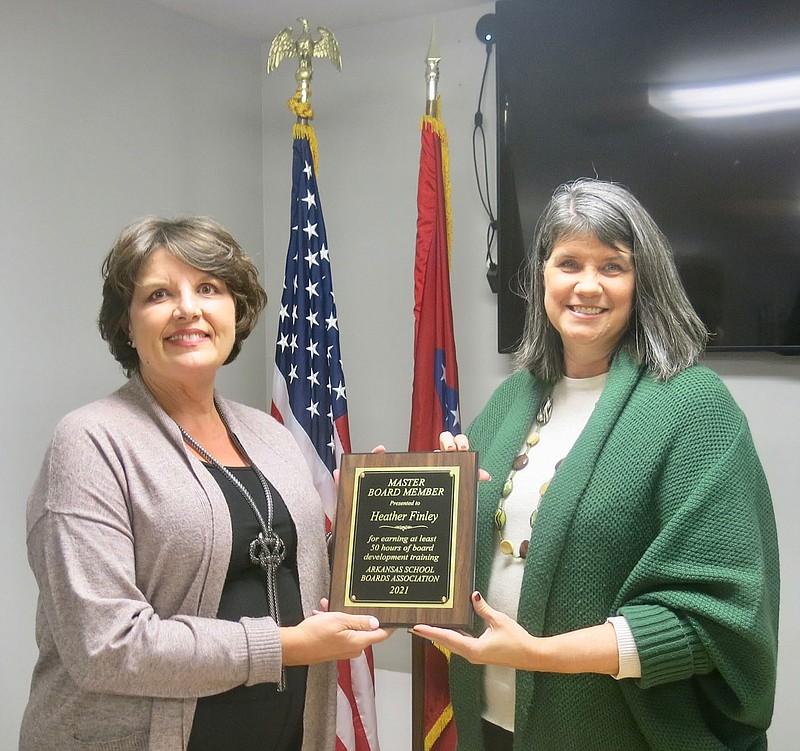 Westside Eagle Observer/SUSAN HOLLAND
Heather Finley (left), Gravette school board secretary, receives a plaque from school superintendent Maribel Childress designating her as a Master Board Member. Finley received the recognition at the January school board meeting, showing she has completed at least 50 hours of board member development training.