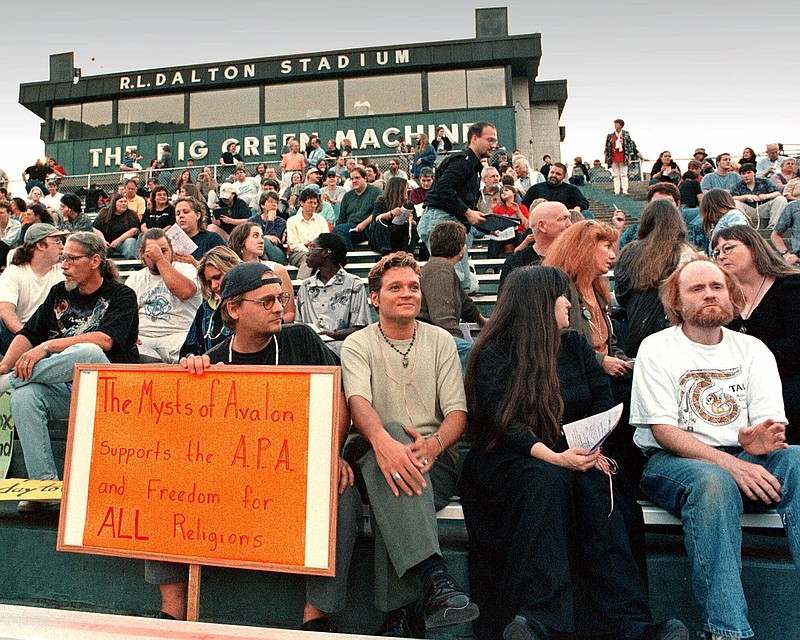 FILE - A pagan holds a sign supporting religious freedom for all religions, shortly before the &quot;We Still Work Magic&quot; rally held at the football stadium on the campus of A.C. Reynolds High School, near Asheville, N.C., Wednesday, Sept. 20, 2000, held in response to the &quot;We Still Pray&quot; rally which was held at the same high school. (AP Photo/Alan Marler, File)