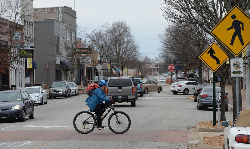 A cyclist rides Friday, Jan. 14, 2022, across Emma Avenue in downtown Springdale. Downtown Springdale has put together a public survey about the Downtown Master Plan for the city. Visit nwaonline.com/220116Daily/ for today's photo gallery.
(NWA Democrat-Gazette/Andy Shupe)