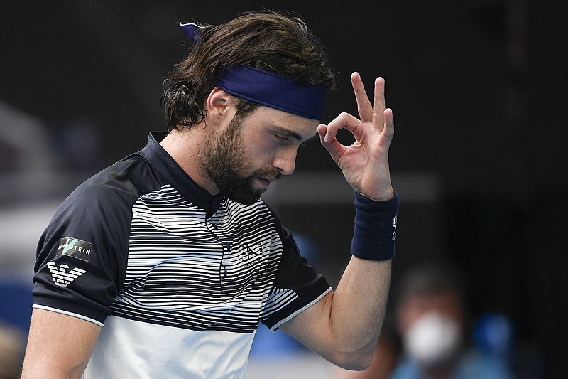 FILE - Nikoloz Basilashvili of Georgia gestures during his first round match against Andy Murray of Britain at the Australian Open tennis championships in Melbourne, Australia, Tuesday, Jan. 18, 2022.  On Friday, Jan. 21, The Associated Press reported on stories circulating online incorrectly claiming three tennis players,  Basilashvili, Nick Kyrgios and Dalila Jakupovic &#x2014; were forced to drop out of this year&#x2019;s Australian Open after they experienced chest-related health issues.(AP Photo/Andy Brownbill)