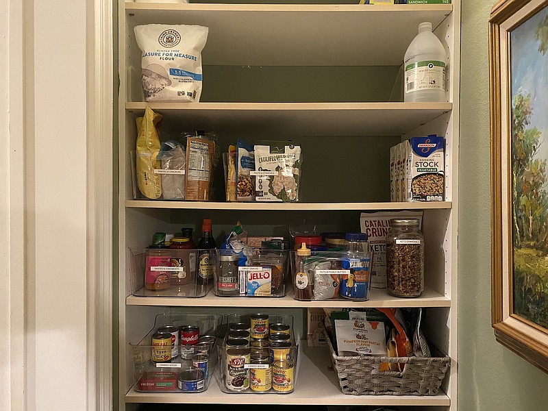 Labeled bins helped organize this pantry, shown after an organizing session. Because bins pull out like drawers, they help make better use of deep shelf space, where goods in back can get lost. Labels make finding and retrieving items faster. (Courtesy Marni Jameson)