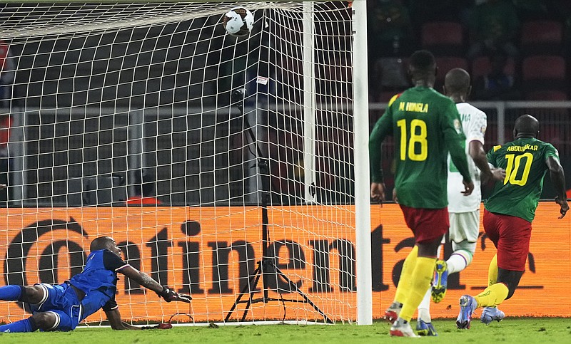 Comoros' goalkeeper Chaker Alhadhur, left, fails to stop a goal shot from Cameroon's Vincent Aboubakar, far right, during the African Cup of Nations 2022 round of 16 soccer match between Cameroon and Comoros at the Olembe stadium in Yaounde, Cameroon, Monday, Jan. 24, 2022. (AP Photo/Themba Hadebe)