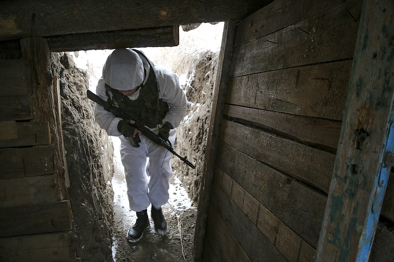 A serviceman walks along a trench on the territory controlled by pro-Russian militants near at frontline with Ukrainian government forces in Slavyanoserbsk, Luhansk region, eastern Ukraine, Tuesday, Jan. 25, 2022. Ukraine's leaders sought to reassure the nation that a feared invasion from neighboring Russia was not imminent, even as they acknowledged the threat is real and prepared to accept a shipment of American military equipment Tuesday to shore up their defenses. (AP Photo/Alexei Alexandrov)