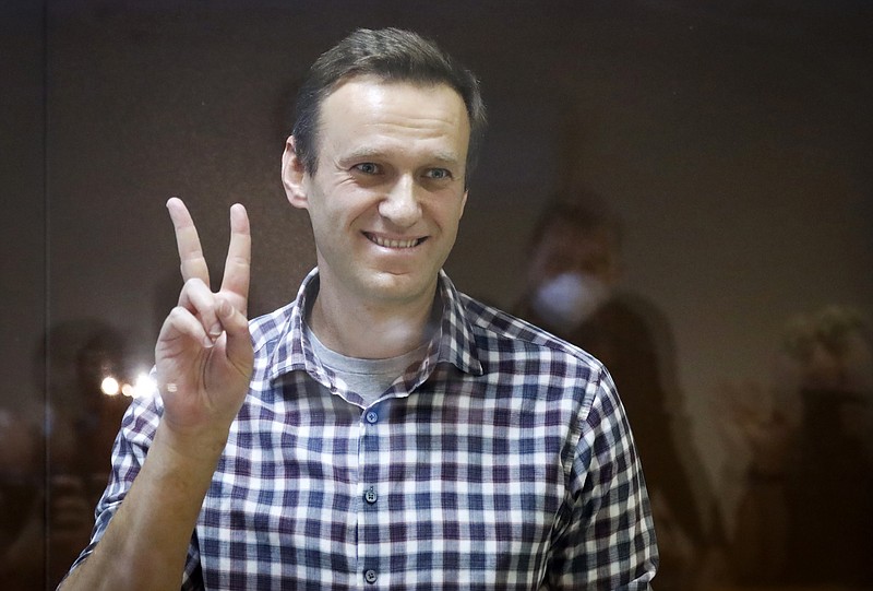 Russian opposition leader Alexei Navalny gestures as he stands in a cage in the Babuskinsky District Court in Moscow, Russia, Saturday, Feb. 20, 2021. Russian authorities have added imprisoned opposition leader Alexei Navalny and some of his top allies to the registry of terrorists and extremists, the latest move in a multi-pronged crackdown on opposition supporters, independent media and human rights activists. (AP Photo/Alexander Zemlianichenko, File)