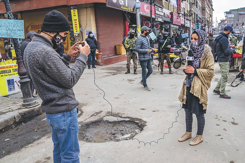 Kashmiri Journalists work during surprise search of pedestrians by security forces in Srinagar, Indian controlled Kashmir, Friday, Jan. 21, 2022. Local Kashmiri reporters were often the only eyes on the ground for the global audiences, particularly after New Delhi barred foreign journalists from the region without official approval a few years ago. Most of the coverage has focused on the Kashmir conflict and government crackdowns. Authorities are now seeking to control any narrative seen opposite to the broad consensus in India that the region is an integral part of the country.  (AP Photo/Dar Yasin)