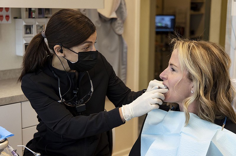 Dentist Rana Stino, left, checks the retainer fit on patient Holly Brown on Jan. 20, 2022, at Water Tower Dental Care in Chicago. Brown wears a retainer to protect her teeth from grinding. (Brian Cassella/Chicago Tribune/TNS)