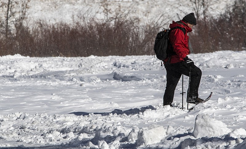 A snowshoer walks along a road in Big Bear Lake, California, after a December storm dumped nearly a foot of snow in the San Bernardino Mountains. (Brian van der Brug/Los Angeles Times/TNS)