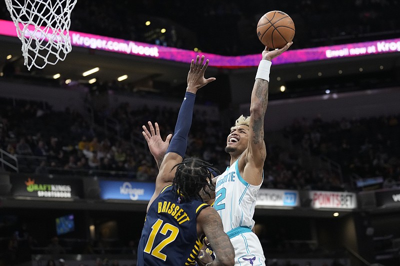 Charlotte Hornets guard Kelly Oubre Jr., right, shoots over Indiana Pacers forward Oshae Brissett during the first half of an NBA basketball game in Indianapolis, Wednesday, Jan. 26, 2022. (AP Photo/AJ Mast)