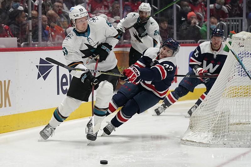 San Jose Sharks defenseman Nicolas Meloche (53) and Washington Capitals left wing Conor Sheary (73) fight for the puck during the first period of an NHL game Wednesday in Washington. – Photo by Evan Vucci of The Associated Press