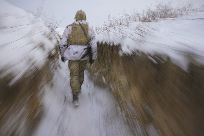 A Ukrainian serviceman walks through a trench on the front line in the Luhansk area, eastern Ukraine, Thursday, Jan. 27, 2022. The U.S. rejection of Russia's main demands to resolve the crisis over Ukraine left "little ground for optimism," the Kremlin said Thursday, but added that dialogue was still possible. (AP Photo/Vadim Ghirda)