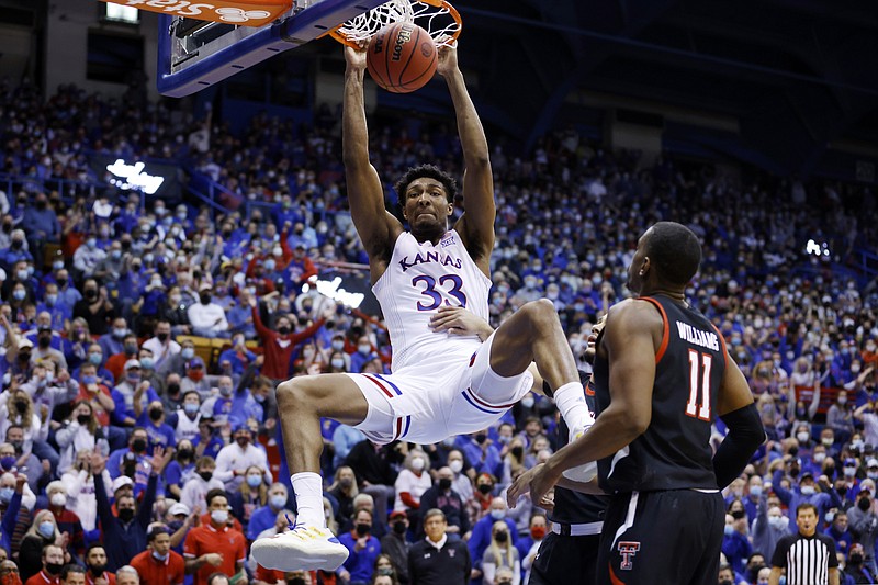 Kansas forward David McCormack (33) dunks over Texas Tech forward Bryson Williams (11) during the first half of an NCAA college basketball game on Monday, Jan. 24, 2022 in Lawrence, Kan. (AP Photo/Colin E. Braley)