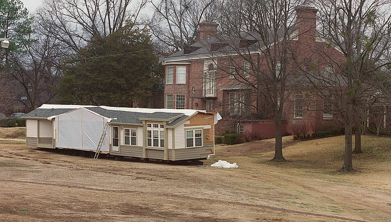 A section of the triple-wide mobile home that was the temporary residence of Gov. Mike Huckabee and his family waits to be removed behind the renovated Arkansas Governor's Mansion in Little Rock on Jan. 30, 2002. The mobile home was moved onto the mansion grounds in August 2000. (Democrat-Gazette file photo)