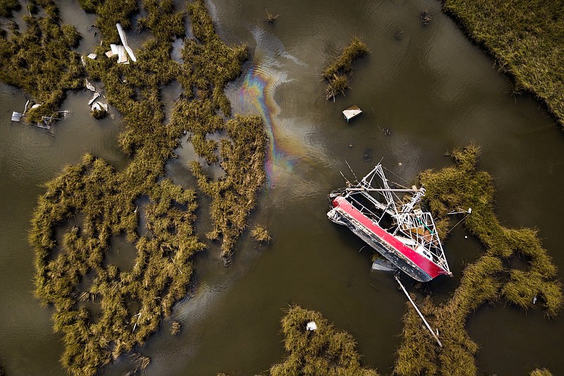 A boat belonging to St. Vincent Seafood Company still sits where Hurricane Ida pushed it into the marsh near their company’s headquarters in Golden Meadow, La. Ngoc and Trung Tran, owners of St. Vincent Seafood Company, have yet to recover the boat. (The New York Times/Edmund D. Fountain)