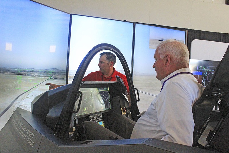 Robert Ator (right), director of military affairs for the Arkansas Economic Development Commission, flies an F-35 simulator Tuesday as Cody Blake, cockpit demonstrator instructor pilot for Lockheed Martin, directs him at TAC Air in Fort Smith. The simulation tutorial was preceded by a talk from 3rd District Rep. Steve Womack, R-Rogers, about the Air Force&#x201a;&#xc4;&#xf4;s selection for the Ebbing Air National Guard base to house up to 36 Lockheed Martin F-35 Lighting IIs and General Dynamics F-16 Fighting Falcons fighter jets for Foreign Military Sales and training.

(NWA Democrat-Gazette/Max Bryan)