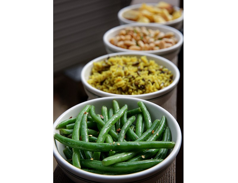 Easy vegetable side dishes lined up from front to back, green beans with mustard sauce, mushroom rice with turmeric, three bean salad and roasted parsnips. (TNS/St. Louis Post-Dispatch/Hillary Levin)