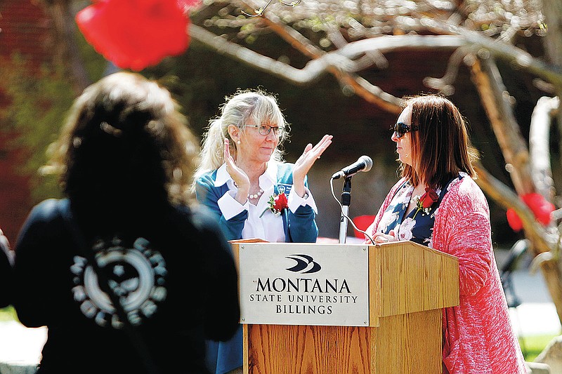 Penny Ronning, center, applauds trafficking survivor Savannah J. Sanders for inspiring the Billings organizers of the Red Sand Project at Peaks to Plains Park at MSU Billings on April 25, 2019, in Billings, Mont. Ronning says sex trafficking and related crimes have long been present in the state but there's more focus on fighting the problem. (Casey Page/The Billings Gazette via AP)