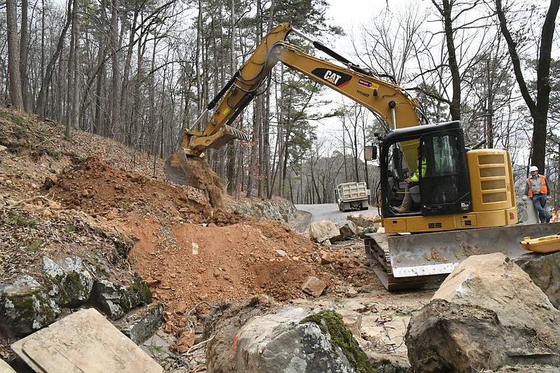 An excavator digs into the side of West Mountain in Hot Springs National Park to expose old drainage culverts so new ones can be installed. - Photo by Tanner Newton of The Sentinel-Record