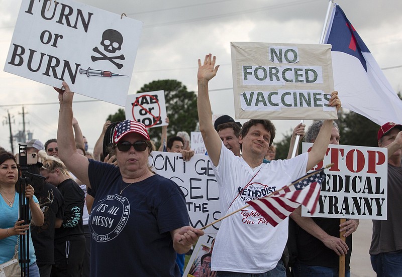 FILE - In this June 7, 2021, photo, demonstrators at Houston Methodist Baytown Hospital in Baytown, Texas, wave at cars that honk at them to support their protest against a policy that says hospital employees must get vaccinated against COVID-19 or lose their jobs. Religious exemptions are increasingly becoming a workaround for hospital and nursing home staff who want to keep their jobs in the face of federal COVID-19 vaccine mandates that are going into effect nationwide this week. (Yi-Chin Lee/Houston Chronicle via AP, File)