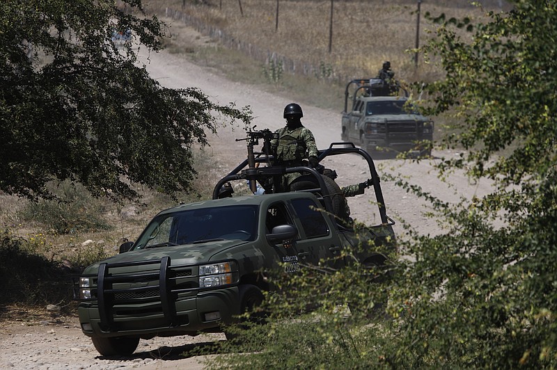 Mexican soldiers patrol near Naranjo de Chila in the municipality of Aguililla, Mexico, Friday, Feb. 18, 2022. The town had been the scene of a bloody turf battle between two drug cartels. Earlier this month the government sent a large army contingent to free the zone from organized crime. (AP Photo/Armando Solis)