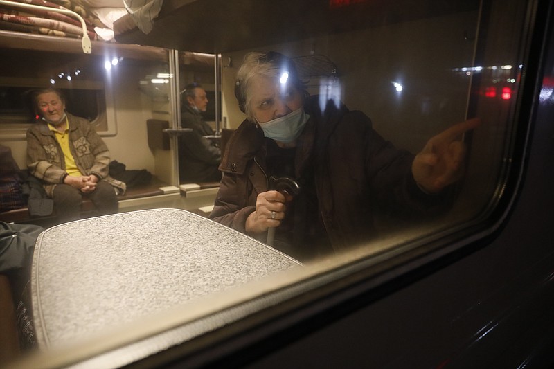 People from the Donetsk and Luhansk regions, the territory controlled by a pro-Russia separatist governments in eastern Ukraine, sit a train carriage waiting to be taken to temporary residences in the Volgograd region, at the railway station in Volzhsky, Volgograd region, Russia, on Sunday, Feb. 20, 2022. Ukrainian President Volodymyr Zelenskyy, facing a sharp spike in violence in and around territory held by Russia-backed rebels and increasingly dire warnings that Russia plans to invade, has called for Russian President Vladimir Putin to meet him and seek a resolution to the crisis. (AP Photo/Alexandr Kulikov)