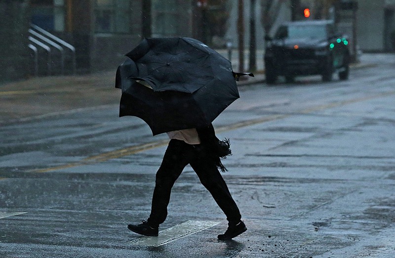 A pedestrian is buffeted by winds and rain as a storm rolls over downtown Little Rock on Tuesday, Feb. 22, 2022. (Arkansas Democrat-Gazette/Colin Murphey)