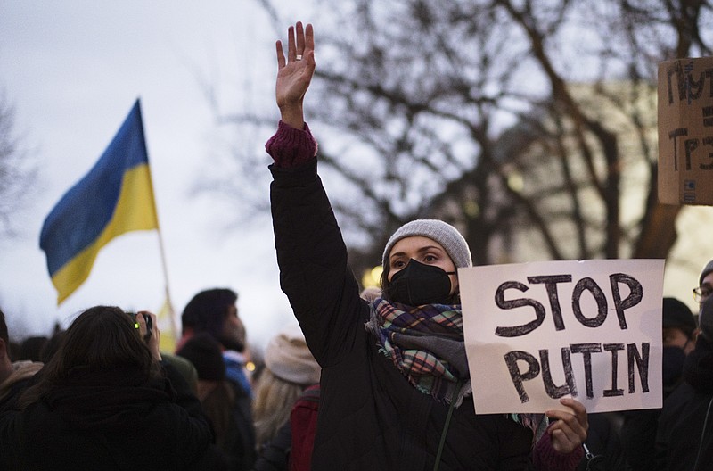 A woman shows a poster in support of the Ukraine at a demonstration along the street near the Russian embassy to protest against the escalation of the tension between Russia and Ukraine in Berlin, Germany, Tuesday, Feb. 22, 2022. Lawmakers gave Russian President Vladimir Putin permission to use military force outside the country on Tuesday. The move that could presage a broader attack on Ukraine after the U.S. said an invasion was already underway there.  (AP Photo/Markus Schreiber)