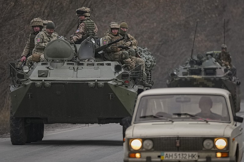 The Associated Press
Ukrainian servicemen sit atop armored personnel carriers driving on a road in the Donetsk region, eastern Ukraine, on Thursday. Russian President Vladimir Putin on Thursday announced a military operation in Ukraine and warned other countries that any attempt to interfere with the Russian action would lead to "consequences you have never seen."