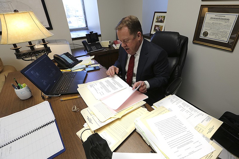 Public defender Kent Krause goes over case files between cases during court hearings via Zoom on Thursday, Feb. 10, 2022, in his office at the Pulaski County Administration Building in Little Rock. (Arkansas Democrat-Gazette/Thomas Metthe)
