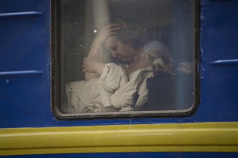 A woman sits by the window of a Lviv-bound train, in Kyiv, Ukraine, Thursday, March 3, 2022. Ukrainian President Volodymyr Zelenskyy's office says a second round of talks with Russia aimed at stopping the fighting that has sent more than 1 million people fleeing over Ukraine's borders, has begun in neighboring Belarus, but the two sides appeared to have little common ground. (AP Photo/Vadim Ghirda)