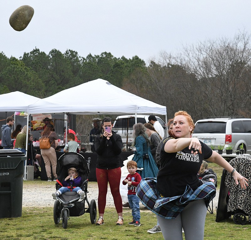 Kathy Lenahan, of Benton, throws a stone Saturday while competing in the Ouachita Highland Games at Cedar Glades Park. - Photo by Tanner Newton of The Sentinel-Record