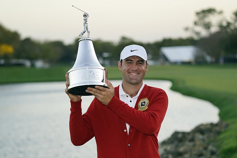 Scottie Scheffler holds up the championship trophy after winning 1the Arnold Palmer Invitational golf tournament Sunday, March 6, 2022, in Orlando, Fla. (AP Photo/John Raoux)