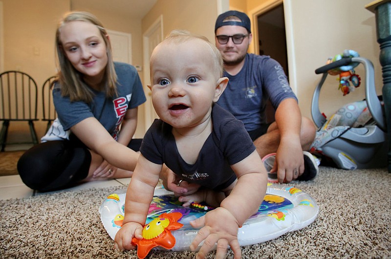 NWA Democrat-Gazette/DAVID GOTTSCHALK Jaylee Kelley and his wife Madalyn play Wednesday, August 1, 2018, with their son Payton inside their apartment in Fayetteville. Teen fathers in northwest Arkansas, like Kelley, have limited parental support resources. The Teen Action and Support Center is working on a teen father mentor group to change that.